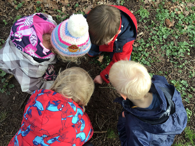 A group of nursery children exploring the outdoors